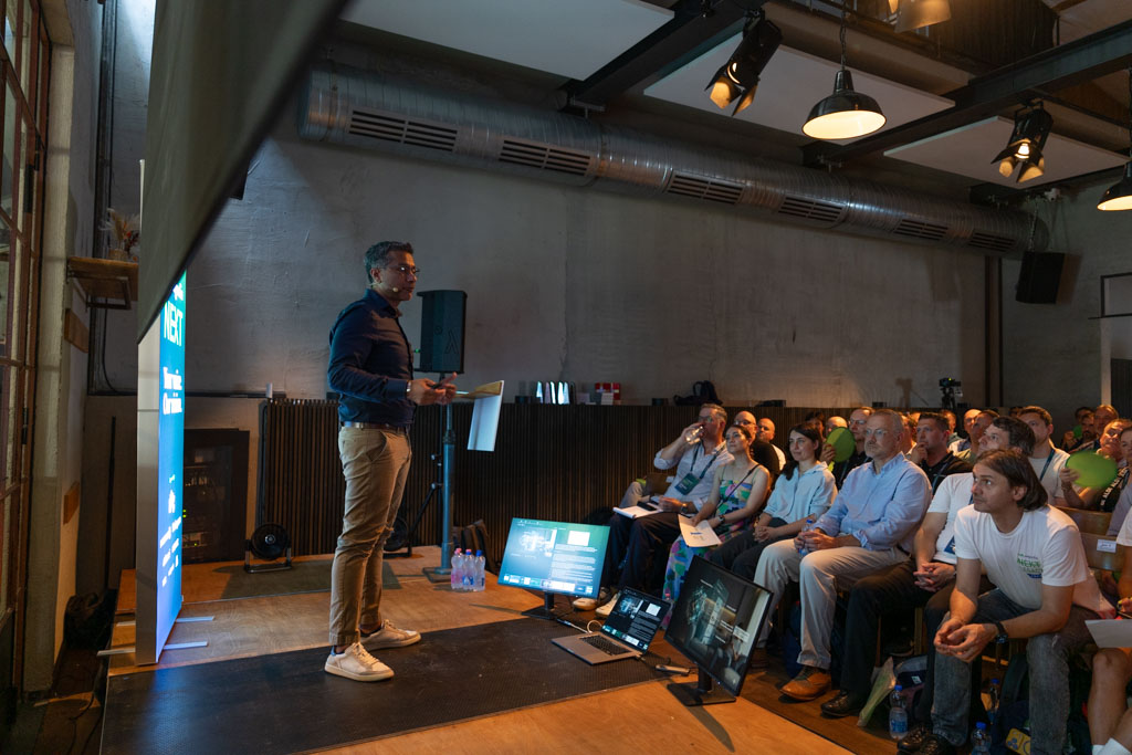 A speaker addressing the audience from the Main Stage in the industrial event venue