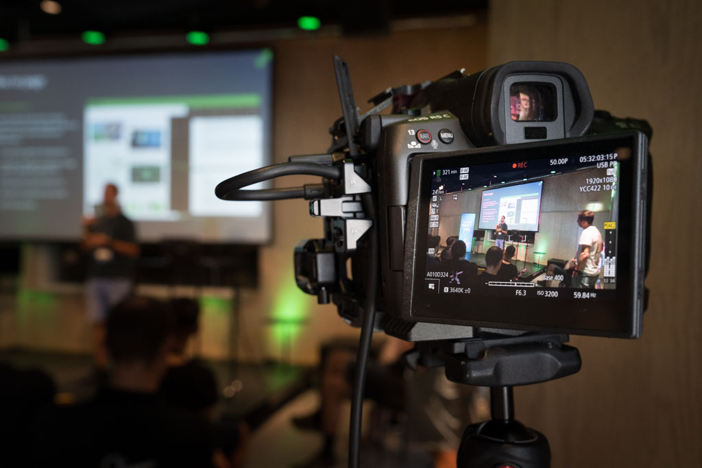 A DevDay speaker presenting the Hybrid Search talk — combining full-text and semantic search — at NEXT Studios